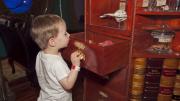 A child peaking into a drawer filled with curiosities